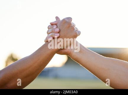 Im always up for some friendly competition. two unrecognizable men holding hands. Stock Photo