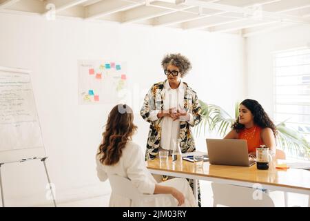 Senior businesswoman having a discussion with her colleagues in a boardroom. Group of businesswomen sharing creative ideas during a meeting. businessw Stock Photo