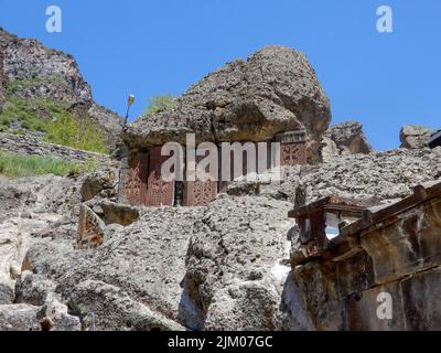 A low angle shot of carved stones from the medieval era on rocky hillside in Armenia Stock Photo