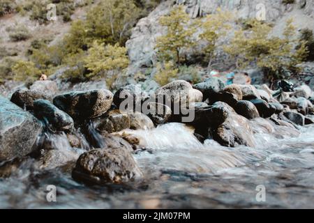 A small river stream flows through the rocks. Stock Photo