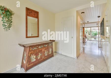 Interior of modern flat in minimal style with narrow empty corridor illuminated by lamps Stock Photo