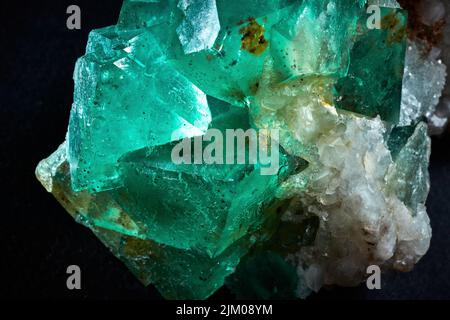 A closeup of a rare mineral row uncut green and white crystal Stock Photo