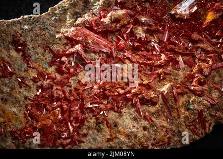 A closeup of a rare mineral row uncut red crystal Stock Photo