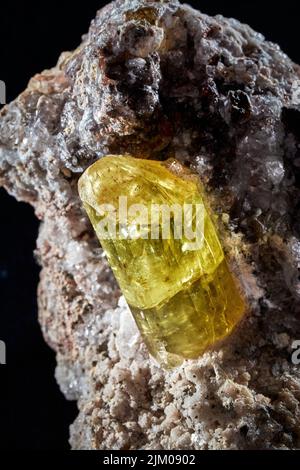 A vertical closeup of a rare mineral row uncut yellow crystal Stock Photo