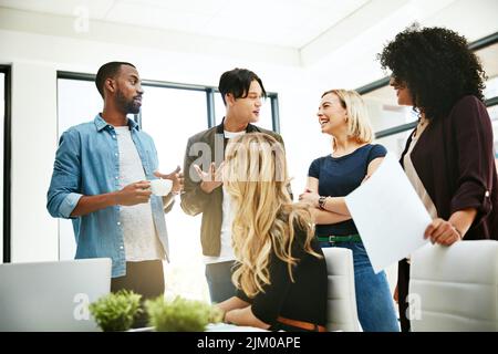 Diverse and cheerful meeting with business people talking, working, planning strategy for project report or paper work. Busy colleagues brainstorming Stock Photo