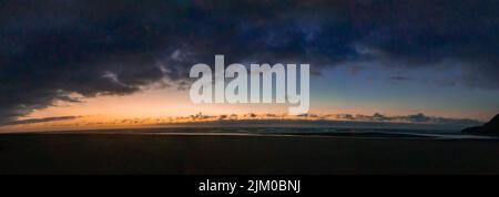 A panoramic scene landscape view of gray sunset dark sky on majestic blue water sea, wallpaper and background Stock Photo