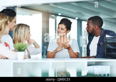 Diverse, listening and smiling businesspeople in meeting talking, discussing and planning work schedule in modern workplace. Team leader having staff Stock Photo