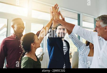 Corporate businesspeople celebrate success in an office. Passionate people feeling motivated, confident and cheerful. Excited, smiling and diverse Stock Photo