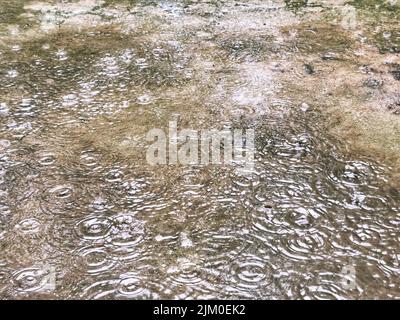 Rainy day. Raindrops fall on the floor forming circular patterns. monsoon concept. Stock Photo