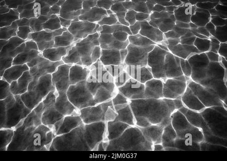 A grayscale view of the shiny clear water of the ocean in Maui County, Hawaii, United States Stock Photo