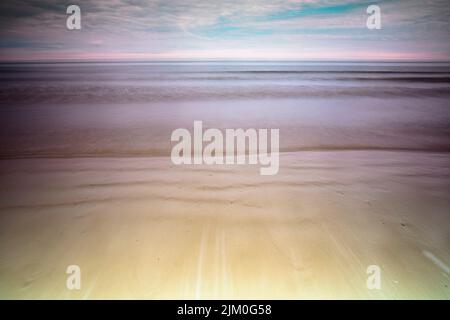 A mesmerizing scene of water by blue sunset on the horizon in Cromer Beach, Norfolk, UK Stock Photo