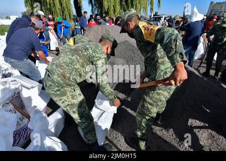 August 3, 2022, San Mateo Atenco, Mexico City, Mexico: August 3 in San Mateo Atenco, Mexico : Neighbors, civil protection elements and military personnel belonging to the 25th Infantry Battalion, applied Plan DN-III-E in its prevention phase, by placing ''costaleras'' along 4 kilometers of the perimeter of the Lerma River, a place where every rainy season it suffers overflows and severe flooding in homes in the area. on August 3, 2022 in San Mateo Atenco, Mexico. (Credit Image: © Arturo HernÃ¡Ndez/eyepix via ZUMA Press Wire) Stock Photo