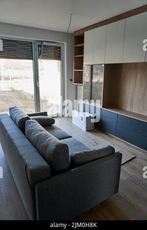 A vertical shot of a new sofa standing in an apartment under renovation on the Bernata street Stock Photo
