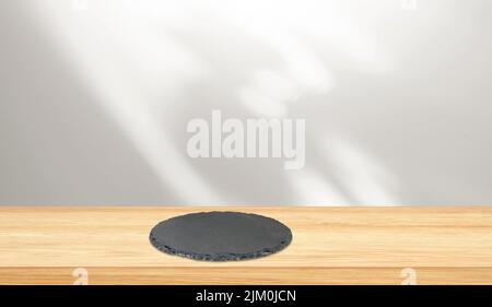 Wooden tabletop and round black slate on surface with free space for creativity ideas Stock Photo