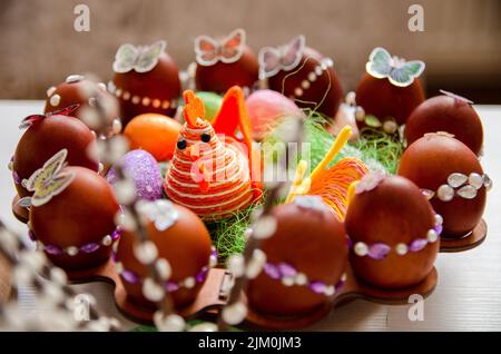 Closeup shot of decorated eggs for Easter on round wooden Easter egg storage rack Stock Photo