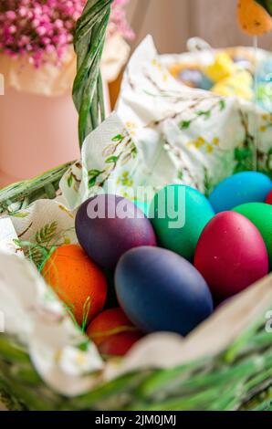 A closeup shot of green and blue Easter eggs and candies on a light ...