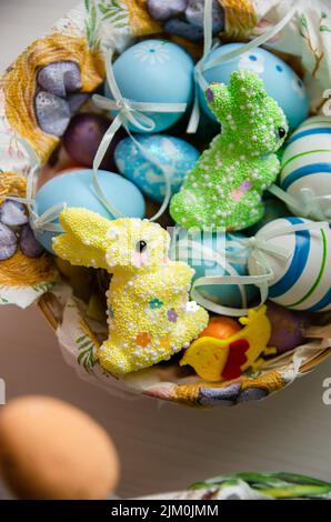 Vertical closeup shot of blue and white foam eggs and bunny decorations in a basket for Easter Stock Photo