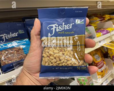Augusta, Ga USA - 04 15 22: Hand holding Fisher bagged nuts Pine Nuts retail store Stock Photo