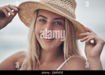 A good hat puts me in a good mood. a beautiful young woman spending the day at the beach. Stock Photo