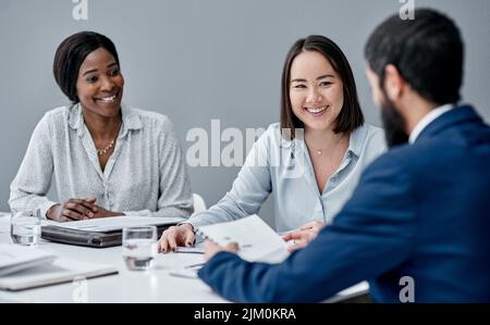 Building on each others ideas like a pyramid puzzle. a businesswoman having a meeting with her colleagues in an office. Stock Photo