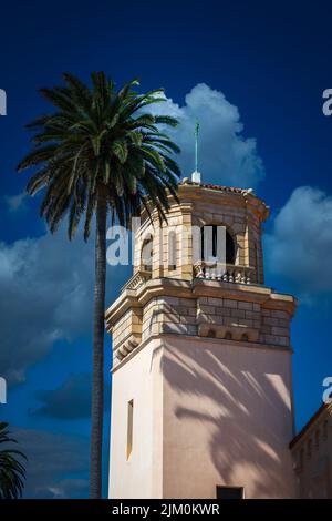 SPANISH STYLED STEEPLE WITH A PALM TREE NEXT TO IT AND A DEEP BLUE SKY WITH A FEW WHITE CLOUDS IN LA JOLLA CALIFORNIA Stock Photo