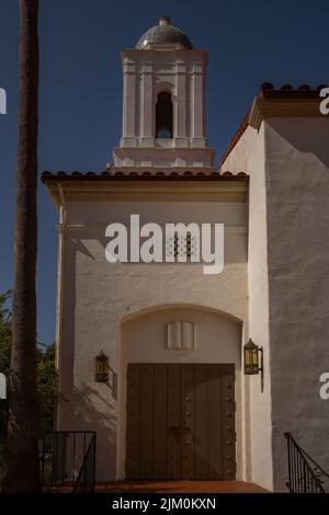 THE ENTRANCE TO A SPANISH STYLED CHURCH WITH A LIGHT BLUE DOME AND WOODEN DOUBLE DOORS AND A NICE SKY IN LA JOLLA CALIFORNIA Stock Photo
