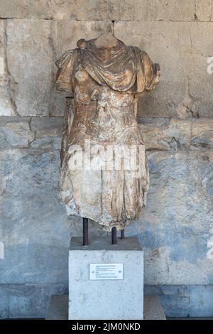 A vertical shot of an Athens headless sculpture in front of a building Stock Photo