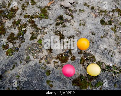 Three colored easter eggs on a stone Stock Photo