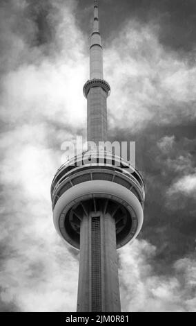 A vertical grayscale low angle shot of CN Tower against the cloudy sky. Toronto, Canada. Stock Photo