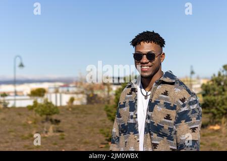 Portrait of smiling man wearing sunglasses outdoors on summer Stock Photo