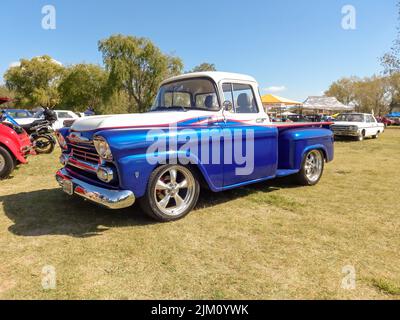 Chascomus, Argentina - Apr 9, 2022: Old blue utility Chevrolet Chevy Apache V8 pickup truck 1958 by GM in the countryside. Side view. Nature grass tre Stock Photo