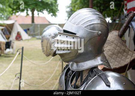Knight helmet of metal with visor down, replica on a medieval camp with historical armor and weapons, copy space, selected focus, narrow depth of fiel Stock Photo