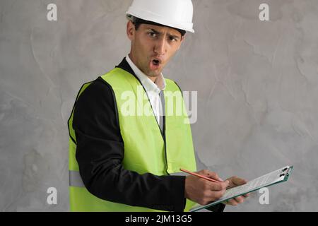 Angry muslim worker, Inspector or engineer is checking and inspecting the building or house by using checklist. An engineer man making notes on his Stock Photo