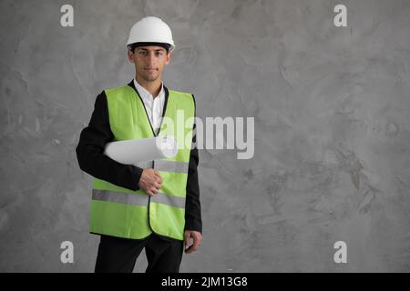Portrait of civil architect studying floor plan, serious civil engineer working with paperwork at construction site. foreman with blueprints on Stock Photo