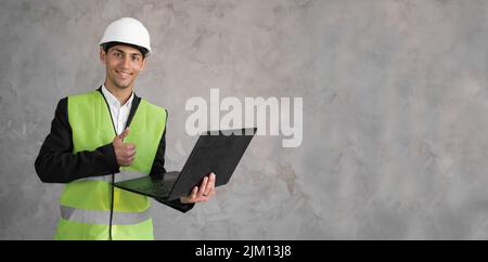 Arabic civil engineer using laptop. Engineering and construction concept. Happy engineer with laptop computer. Man in hard hat. Architect in yellow Stock Photo