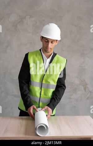 Male arabic engineer with drawing on the table, work architector with blueprint on object. Construction house. Stock Photo