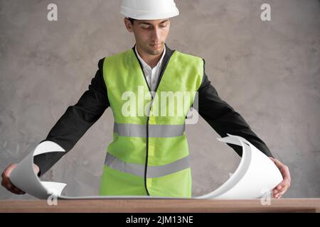 Male arabic engineer with drawing on grey background, Stock Photo