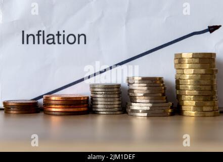 A rising inflation concept with a drawn upward arrow and coins. Stock Photo