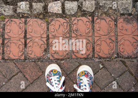 Terracotta tiles on ground at the Fish Quay, in North Shields, UK, with a fish motif. Stock Photo