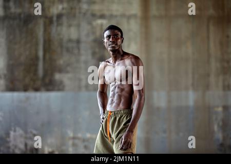 Handsome afro American sportman standing on the street while taking break after training. Black male having rest after workout Stock Photo