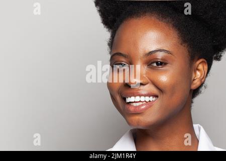 Portrait of beautiful brunette young woman smiling cheerfully, showing her white teeth and looking at camera while feeling happy and carefree Stock Photo