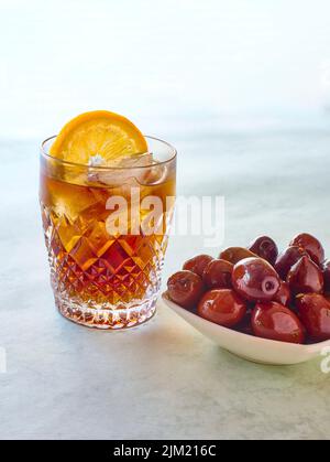 A glass of vermouth served with a classic olives tapa. Stock Photo