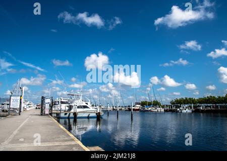 Sailboats and Yachts in calm blue waters of the marina with a bright blue sky above, white clouds, summers day. Punta Gorda, Florida, Fishermans Wharf Stock Photo