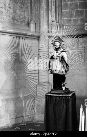 Black and white photo of statue of catholic young male saint inside ancient church in Naples, Italy Stock Photo