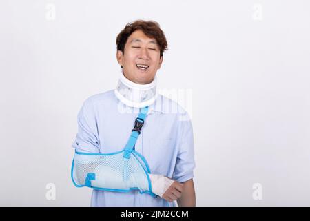 Portrait of a handsome Asian man feeling relaxed eyes closed with broken arm and neck isolated on white background copy space Stock Photo