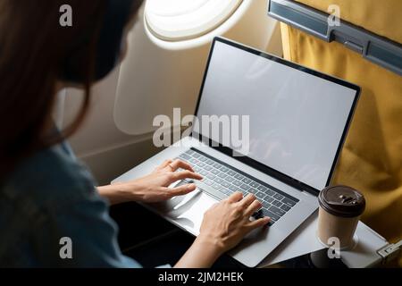 Beautiful asian travel woman using laptop computer in airplane Stock Photo