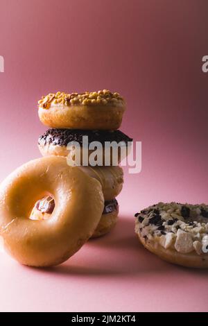 Close-up of fresh donuts stacked against copy space over colored background Stock Photo