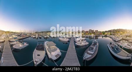 Aerial panorama of Porto Vecchio city harbor at night in Corsica island of France. Drone view of downtown skyline with boats and yachts in port in the Stock Photo