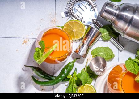 Carrot Ginger Margarita cocktail with lime, mint and hot chili pepper, original vegetable spicy drink on white tiled background copy space Stock Photo
