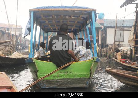 Whanyinna Primary school boat transporting students to school at the Makoko fishing community on the Lagos lagoon. Makoko is a slum community located in Lagos. Established in the 18th century primarily as a fishing village, much of Makoko is made up of structures constructed on stilts, on the edge of the Lagos Lagoon. Nigeria. Stock Photo